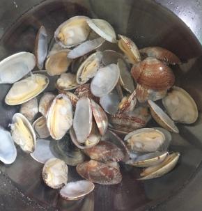 花蛤开口后立即捞出，放入冷水中冲洗一遍。