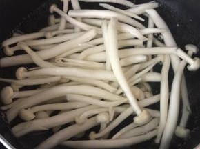 再烧一锅开水（两人份），先下洗干净的白玉菇。