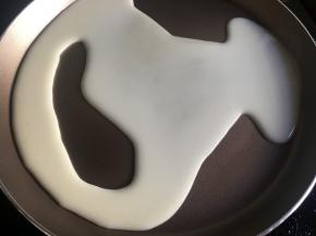 预热千层锅，舀一勺面糊倒入锅中；