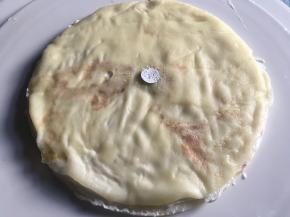 铺好一张饼皮，抹上淡奶油，再取一饼皮铺好，重复至第3张饼皮；对应层数的纸片放在饼皮中间，筛上一层薄薄的糖粉，取出纸片，在中间无糖粉纸片部分抹上调色奶油，其余部分抹上白色奶油，重复上述操作；最后将表面也抹上奶油，进行装饰；