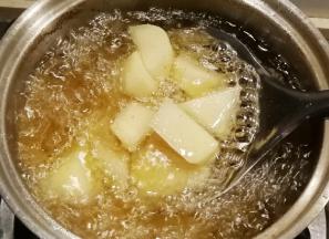 放入土豆炸至金黄捞出控油