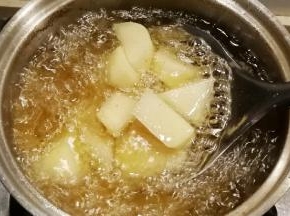 放入土豆炸至金黄捞出控油