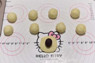 每份按扁后包入5克豆沙，收圆后按扁。