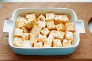 取一个深一点的耐高温盘子，我用的是焗烤碗，普通瓷盘也可以，先把混合好的芋头块铺在盘子底部。