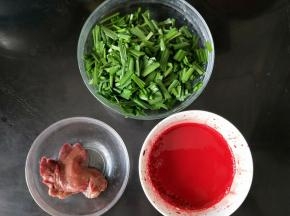 杀鸡之前先准备好一个小碗，里面放1克玉米淀粉、适量盐和10左右的清水，搅拌均匀，然后让鸡血流入碗里，搅拌一两圈后静置让它稍微凝固；韭菜洗干净切成小段备用。
