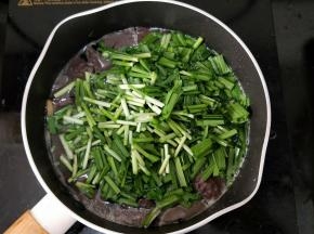 然后倒入韭菜段。