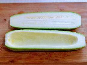 首先将西葫芦洗干净，从中间切开，之后把瓤用小勺挖出来。