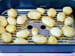 将去皮洗干净的小土豆放蒸屉上。