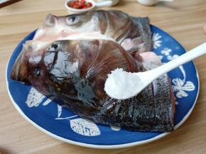 在鱼头内部和外部都切上花刀，便于去腥入味，加盐一勺里外抹均匀。