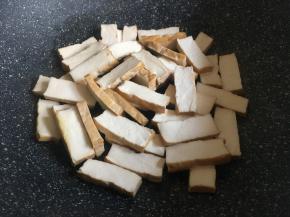 起锅热油，倒入香干，中火慢煎；