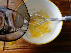 左手一边倒水，右手配合用手动打蛋器搅打。