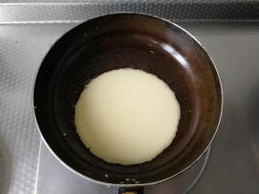 油温热后，倒入1/3面糊，这份面糊可以做三张饼。怕糊可以先关火，倒入面糊，略微晃匀到合适大小，我加了75克水，面糊倒入就摊平了，厚薄均匀。然后开小火，不要移动，等底部面糊凝固后，再晃锅。面饼轻松就可以移动说明一面已经熟了。