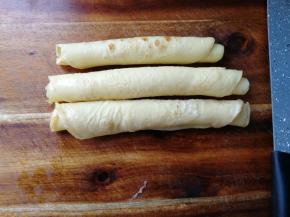 摊开在干净案板上，从下往上卷起。