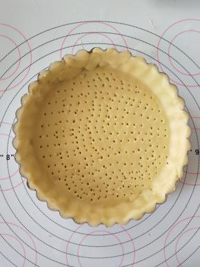 7、将面片铺在派盘上，整形。去掉多余的部分。用叉子扎眼，冷冻20分钟。
