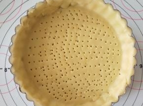 7、将面片铺在派盘上，整形。去掉多余的部分。用叉子扎眼，冷冻20分钟。
