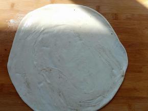 用擀面杖擀成圆形的薄饼