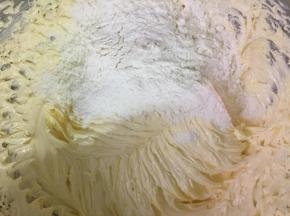 把过筛的面粉和柠檬汁分3次加到黄油糊中，用电动打蛋器搅拌均匀。
