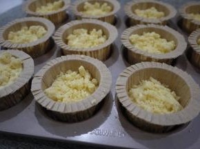 把蛋糕糊装入裱花袋，挤入马芬杯子中。约8分满，然后撒上酥粒。