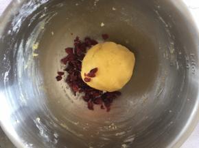 把蔓越莓干切碎，倒入面团抓匀揉成面团。