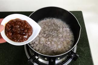 锅中倒入食用油，下入肉末炒熟，加入黄豆酱、料酒和糖。