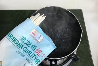 重新往锅中倒入适量的清水煮沸，金龙鱼优+活性发酵空心挂面放入锅中。