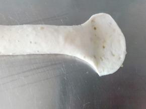 将长条一端用擀面杖擀开，另一端稍微搓细一点