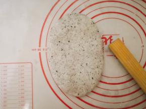 光滑面朝上，用手稍微拍扁，擀成椭圆形，翻面有气泡轻轻拍掉。