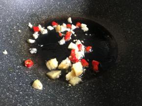 锅中倒入适量油，放入辣椒、大蒜、生姜爆香；