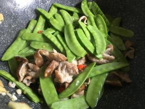 倒入滤干水分的荷兰豆，不停翻炒；