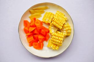 胡萝卜去皮洗净切滚刀块，玉米去须洗净切小块，姜去皮切片。