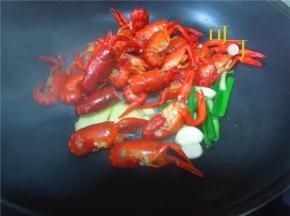 热锅里加适量油，爆香葱姜蒜，加入焯过水的小龙虾翻炒。