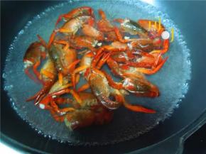 烧开半锅水，把处理好的小龙虾放在里面，烧至虾壳变红，大约3－5分钟，捞起备用。