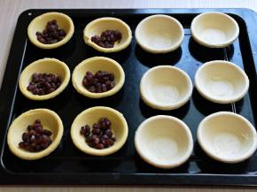 蛋挞皮中放入蜜豆，再倒入做好的蛋挞液，八分满，放入烤盘中。(蜜豆提前做好的，买来的也可以)