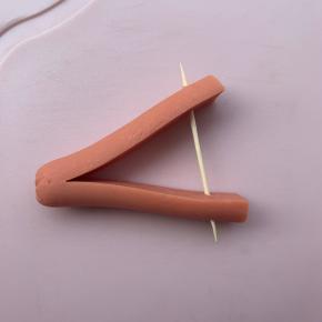 5、取半段，再切一刀，不要切到底，然后插入牙签，把两端分开。