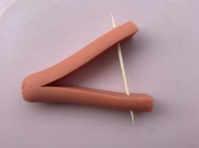 5、取半段，再切一刀，不要切到底，然后插入牙签，把两端分开。