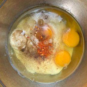 7、烤箱180度预热。然后取个盆，倒入酸奶，打入3个鸡蛋，加盐，黑胡椒粉，辣椒粉（给小朋友吃就不要加辣的了）。