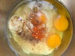 7、烤箱180度预热。然后取个盆，倒入酸奶，打入3个鸡蛋，加盐，黑胡椒粉，辣椒粉（给小朋友吃就不要加辣的了）。