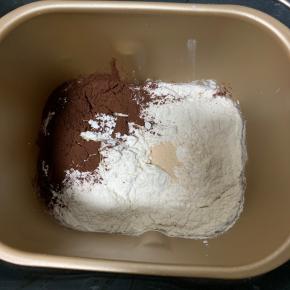 1、除黄油和巧克力豆外的材料，放入面包桶内，先液体后粉类，开启揉面程序揉15分钟。