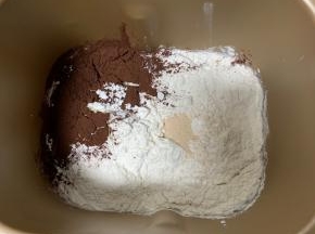 1、除黄油和巧克力豆外的材料，放入面包桶内，先液体后粉类，开启揉面程序揉15分钟。
