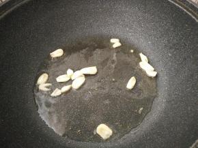 锅内再放适量底油，放入蒜瓣炒香。