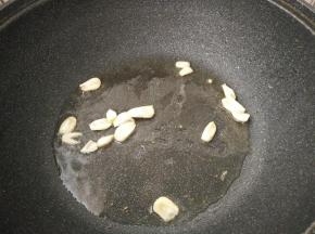 锅内再放适量底油，放入蒜瓣炒香。
