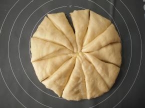 将面团倒在案板上用手轻轻排气，分割成12份。