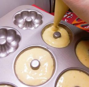 在裱花袋顶端剪掉一个小角形成开口 将蛋糊挤入模具中 不要挤满