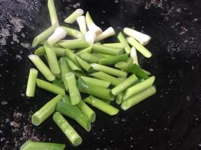 锅留底油，放入蒜梗爆香