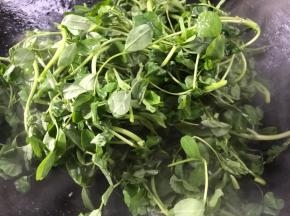 接着开大火，放入黄花草，翻炒均匀