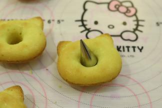 出炉的玛德琳轻轻一推就可以脱模，中间利用裱花嘴切掉多余的蛋糕体。