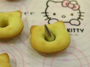 出炉的玛德琳轻轻一推就可以脱模，中间利用裱花嘴切掉多余的蛋糕体。