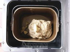 除黄油和黑芝麻外，将面团材料所有原材料倒入东菱面包机的面包桶中，注意酵母不要和盐、糖直接接触，启动一个和面程序，揉到面团较光滑，加入软化好的黄油，继续和面程序15分钟。