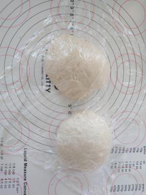 6、取出面团分割成2份，滚圆盖保鲜膜松弛15分钟。
