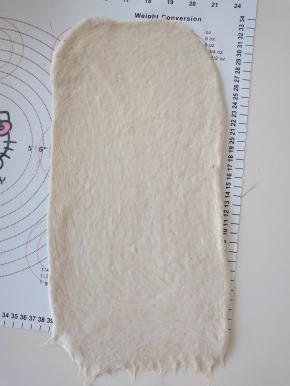 7、取面团擀开，翻面后擀成长方形，压薄底边。
